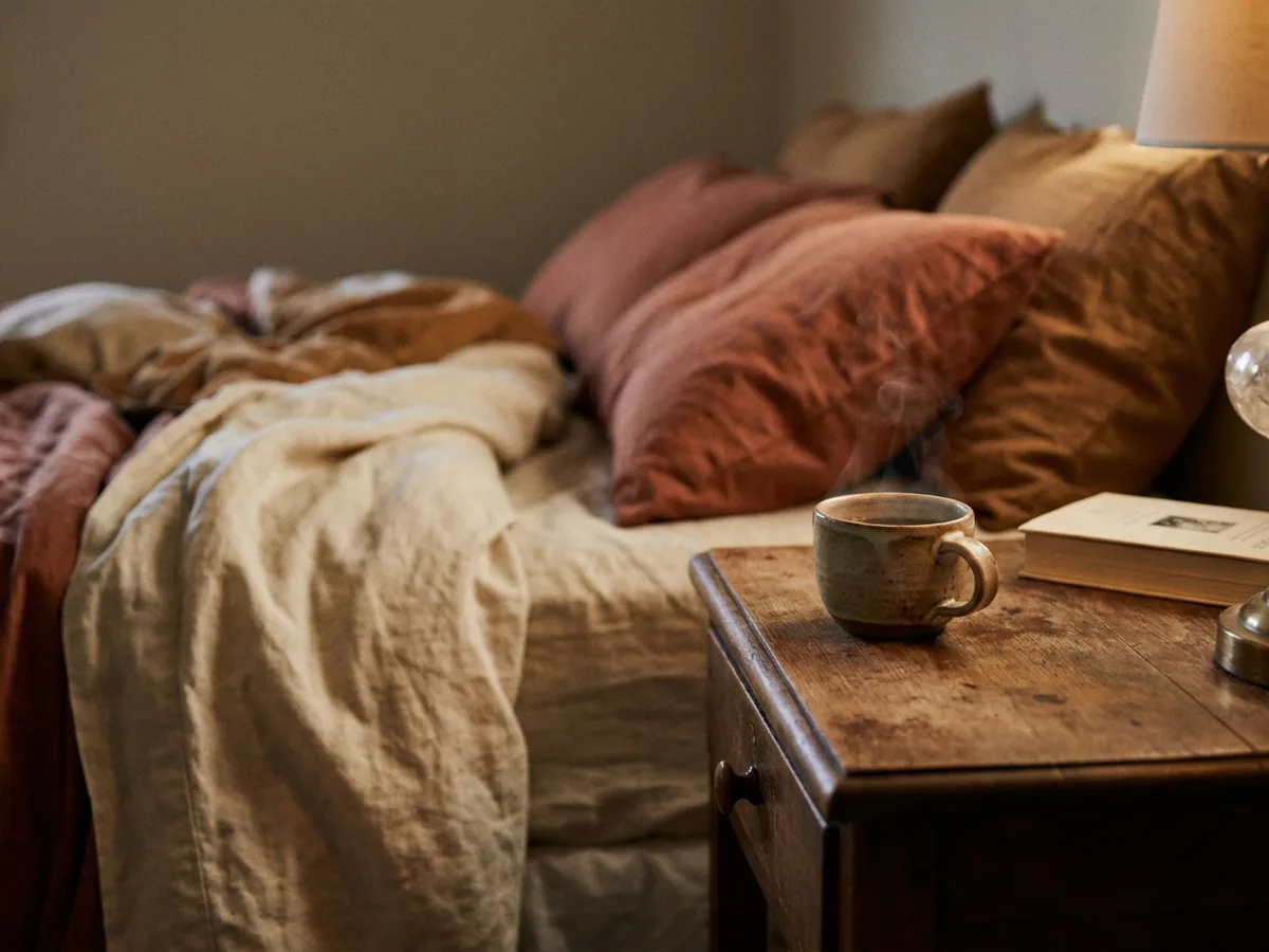 Tasse de café posée sur une table de nuit dans une chambre au crépuscule
